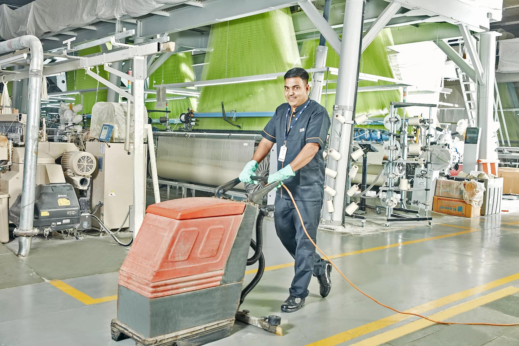 Worker cleaning anti static ESD flooring in industrial facility