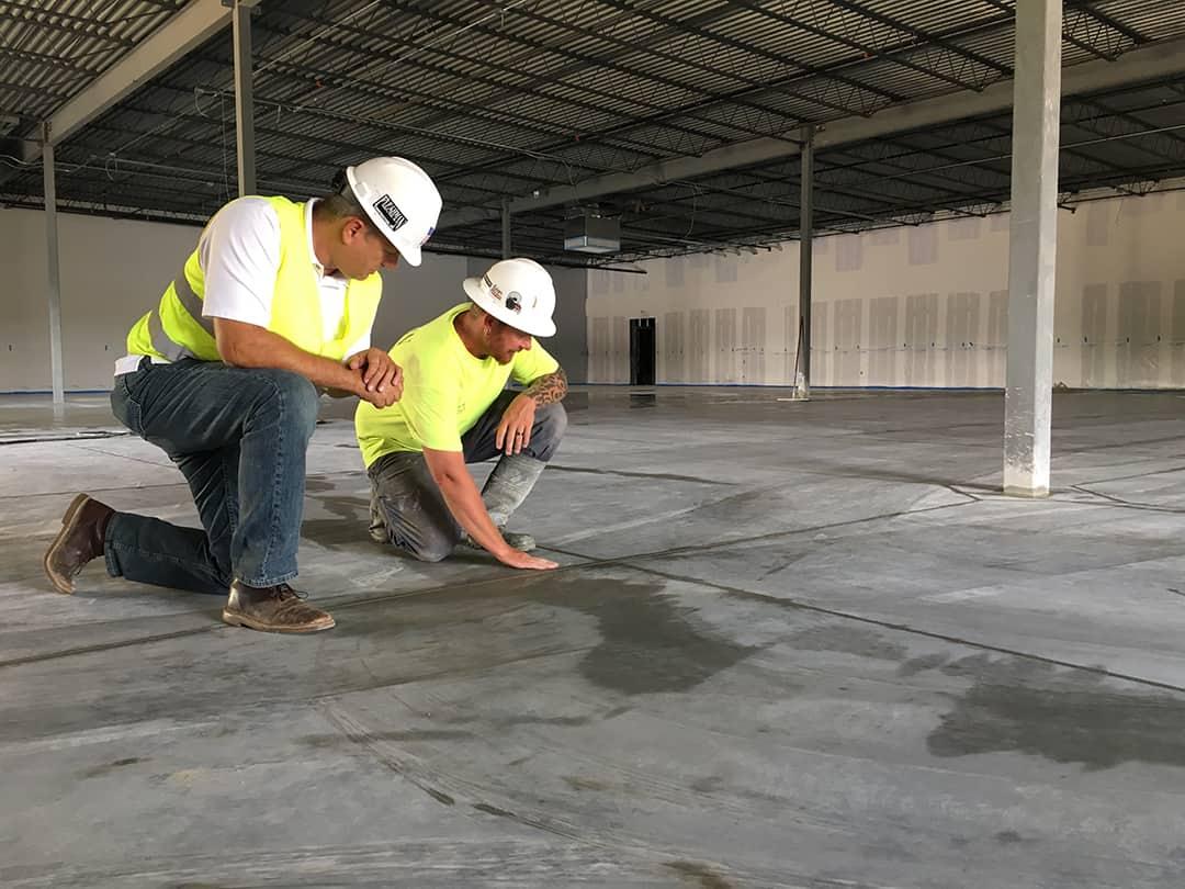 Industrial flooring contractor inspecting factory floor before installation